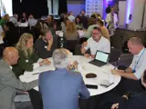 A group of people having a table discussion at an event