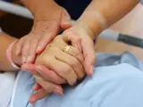 Close up of a nurse holding patient hand showing compassion