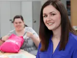 A female member of staff with two people with learning disabilities