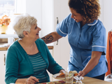 Young female nurse smiling with an elderly woman